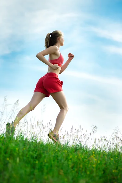 Молодая женщина, бегущая по сельской дороге летнего парка. Упражнения на открытом воздухе. J — стоковое фото