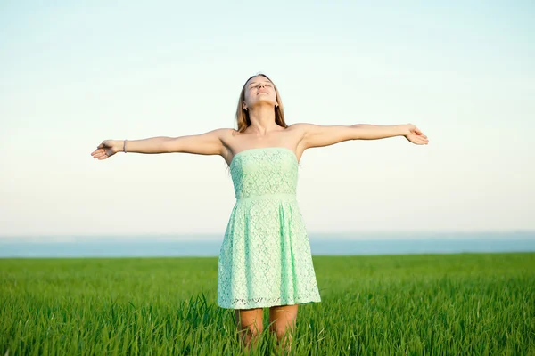 Felicidad mujer estancia al aire libre bajo la luz del sol de la puesta del sol — Foto de Stock