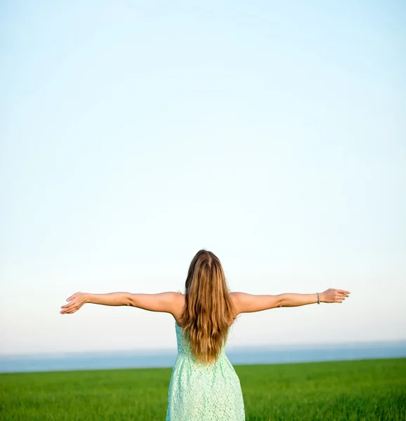 Felicidad mujer estancia al aire libre bajo la luz del sol de la puesta del sol —  Fotos de Stock