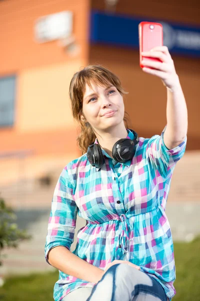 Gelukkig jonge wpman nemen van foto's van zichzelf via mobiele telefoon. Selfie. — Stockfoto