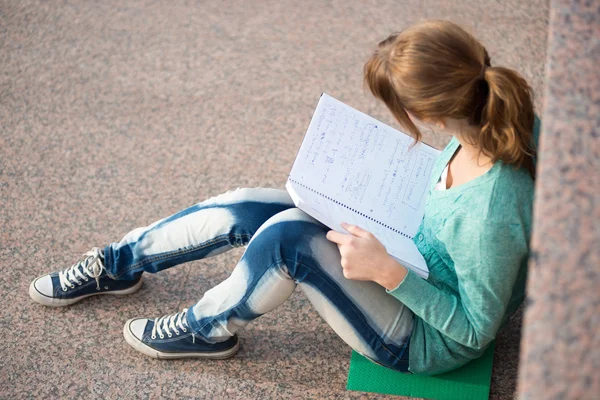 Κορίτσι που κάθονται στα σκαλοπάτια και ανάγνωση σημείωμα — Φωτογραφία Αρχείου