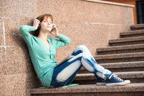 Bella giovane studentessa con le cuffie. Ragazza musica all'aperto — Foto Stock