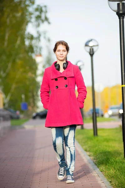 Belle femme en manteau rouge marchant rue d'automne . — Photo