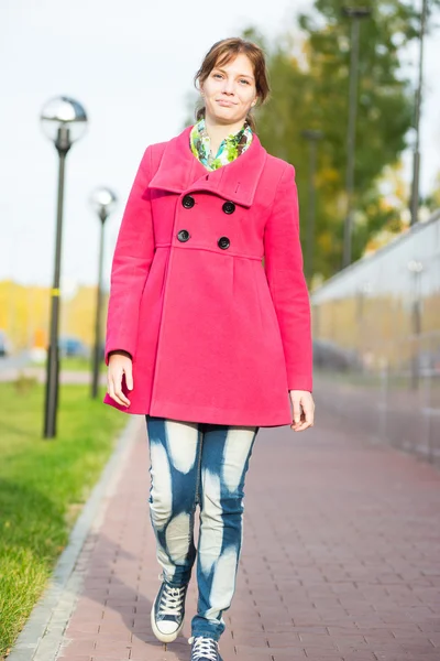 Belle femme en manteau rouge marchant rue d'automne . — Photo