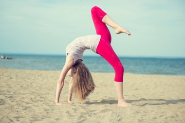 Genç Bayan pratik yoga. Okyanus deniz kıyısına yakın egzersiz.