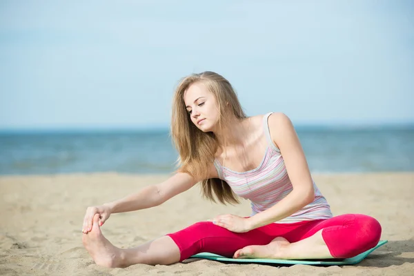 Jonge dame praktizerende yoga. Training in de buurt van de kust van de zee oceaan. — Stockfoto