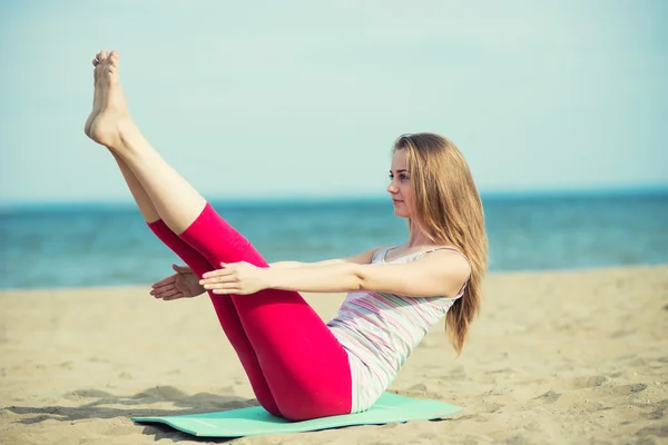 Young lady practicing yoga. Workout near ocean sea coast. — Stock Photo, Image