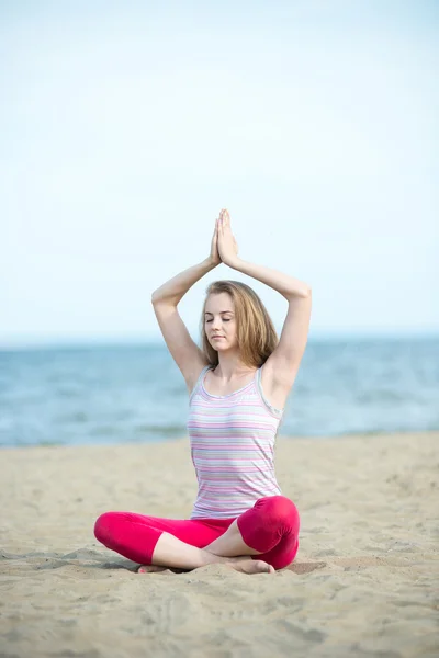 Jonge dame praktizerende yoga. Training in de buurt van de kust van de zee oceaan. — Stockfoto