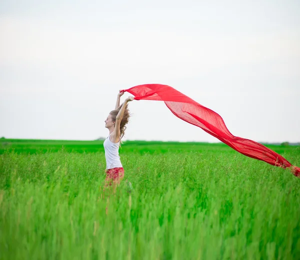 Ung dam runing med vävnader i det gröna fältet. Kvinna med halsduk. — Stockfoto