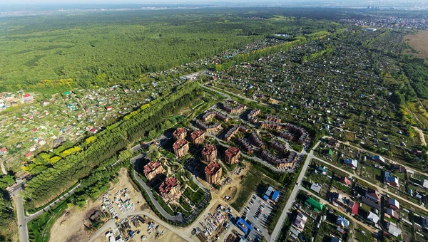 Vista aérea de la ciudad con encrucijada, caminos, casas, edificios, parques, estacionamientos, puentes — Foto de Stock