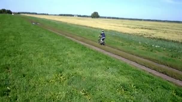 Man fietsen op een landelijke weg. Luchtfoto. — Stockvideo