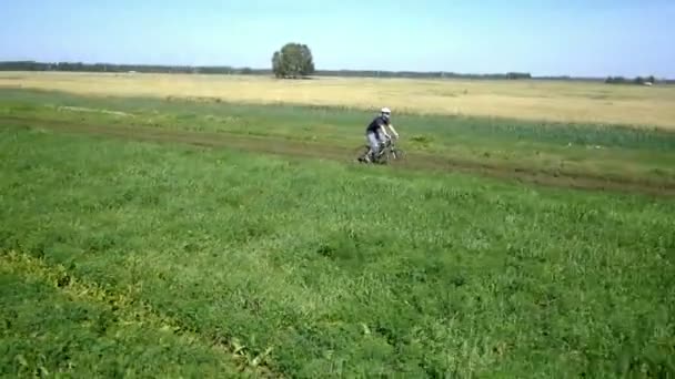 Homem a andar de bicicleta numa estrada rural. Vista aérea . — Vídeo de Stock