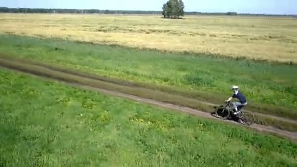 Uomo in bicicletta su una strada rurale. Vista aerea . — Video Stock