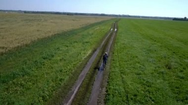 Adam kırsal bir yolda Bisiklete binme. Havadan görünümü.