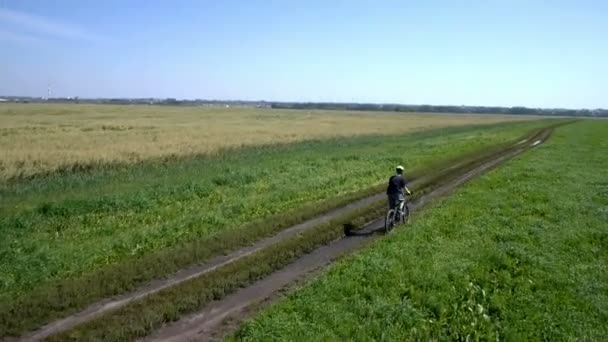 Man fietsen op een landelijke weg. Luchtfoto. — Stockvideo