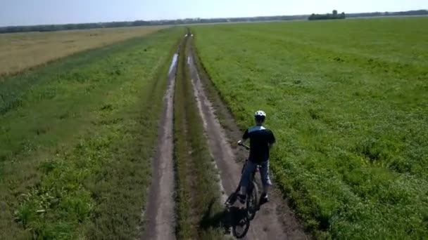 Muž na kole na venkovské cestě. Letecký pohled. — Stock video