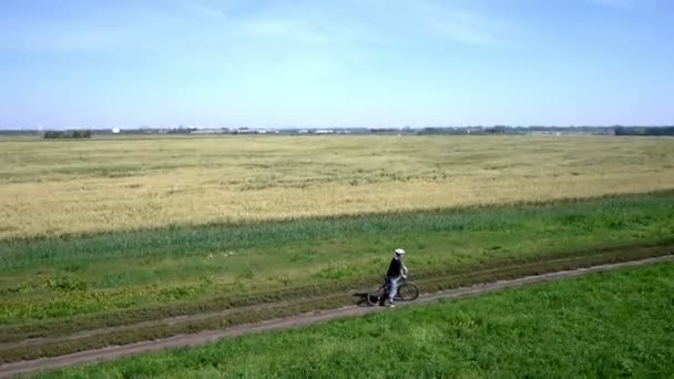 Muž na kole na venkovské cestě. Letecký pohled. — Stock video