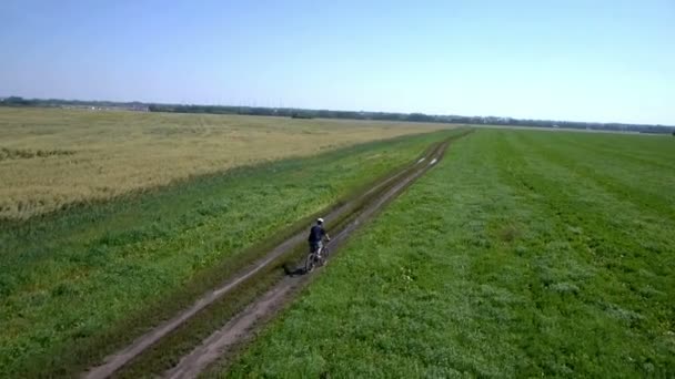 A férfi egy vidéki úton kerékpáros. Légifelvételek. — Stock videók
