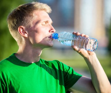 Yorgun bir adam içme suyu fitness sonra plastik bir şişe