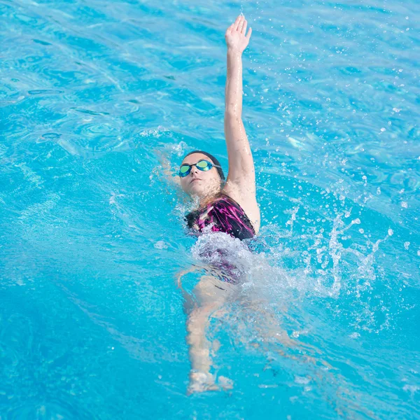 Woman in goggles swimming back crawl style — Stock Photo, Image