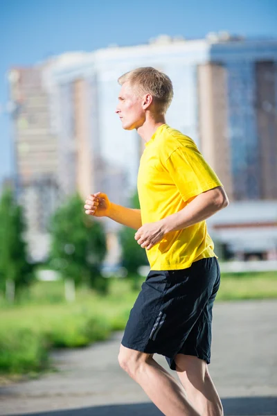 Sportieve man joggen in straat skyline van de stad. Buiten fitness. — Stockfoto