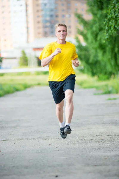 Sportieve man joggen in straat skyline van de stad. Buiten fitness. — Stockfoto