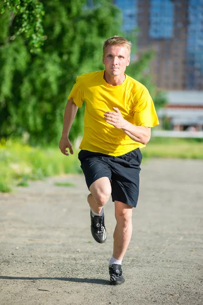 Sportovní muž, běhání v městském parku ulici. Venkovní fitness. — Stock fotografie