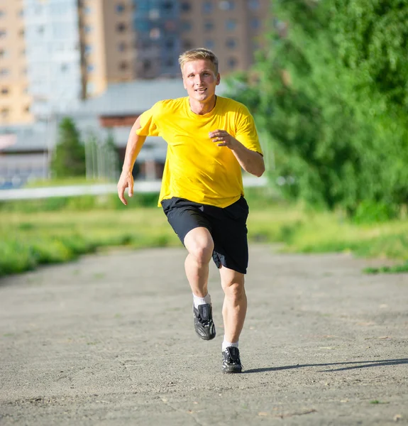 Sporty man jogging in city street park. Outdoor fitness. — Stock Photo, Image