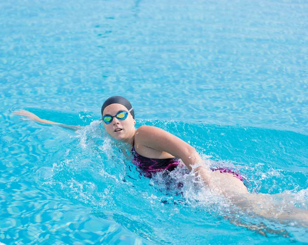 Mulher em óculos nadando frente crawl estilo — Fotografia de Stock