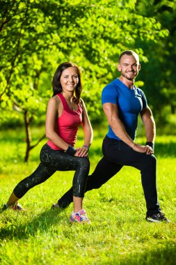 Erkek ve kadın esneme egzersizleri yapıyor.