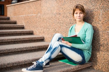 Merdivenlerde oturan ve Not okuma kız