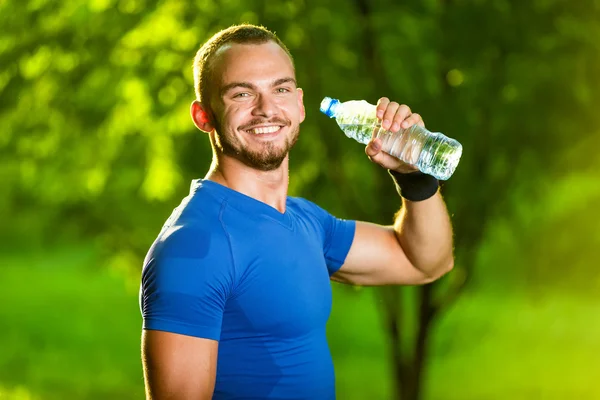 Atlético maduro homem bebendo água de uma garrafa — Fotografia de Stock