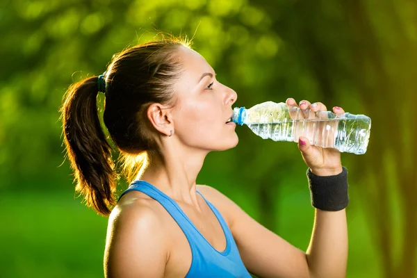 Mujer joven bebiendo agua después del ejercicio físico —  Fotos de Stock