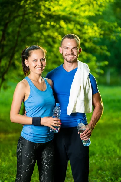 Erkek ve kadın içme suyu şişe fitness spor egzersiz sonrası — Stok fotoğraf