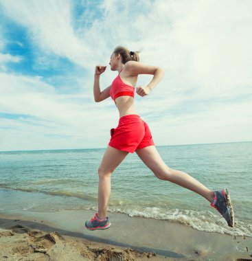 Güneşli yaz kum plajda çalışan genç bayan. Egzersiz. Jog