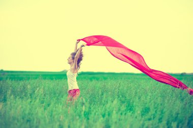 Young lady runing with tissue in green field. 