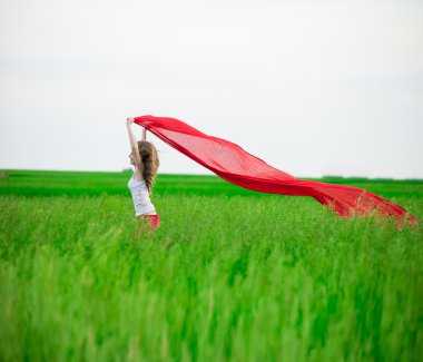 Young lady runing with tissue in green field. 
