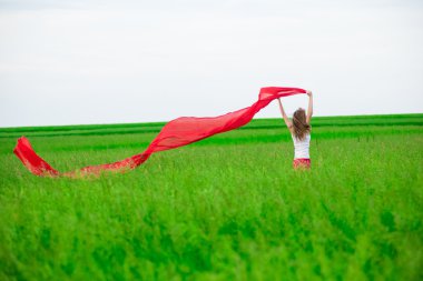 Young lady runing with tissue in green field. 