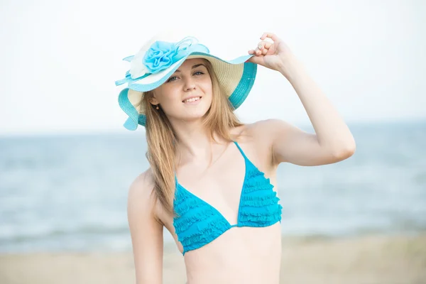 En ung dame solbader på en strand. Smuk kvinde poserer på - Stock-foto