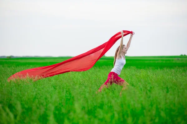 Junge Frau läuft mit Gewebe auf der grünen Wiese. — Stockfoto