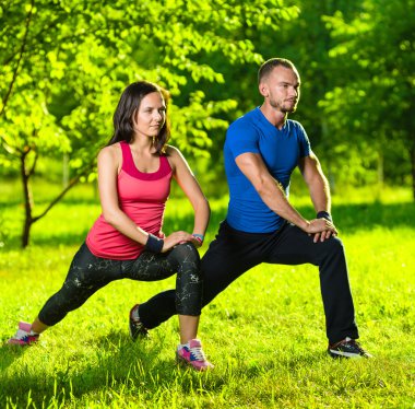 Erkek ve kadın esneme egzersizleri yapıyor.