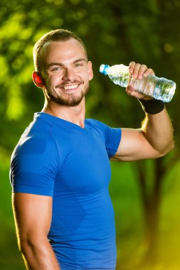 atletik olgun adam içme suyu bir şişe