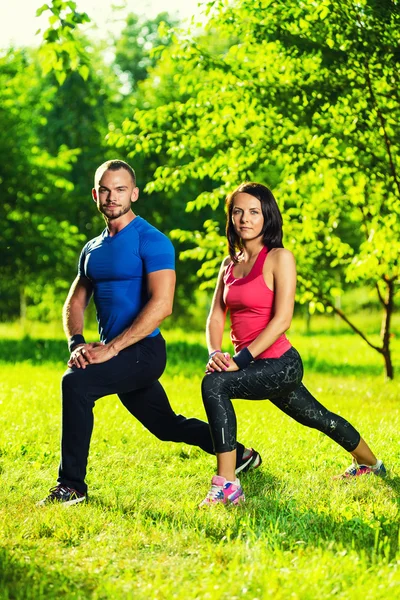 Homem e mulher fazendo exercícios de alongamento — Fotografia de Stock