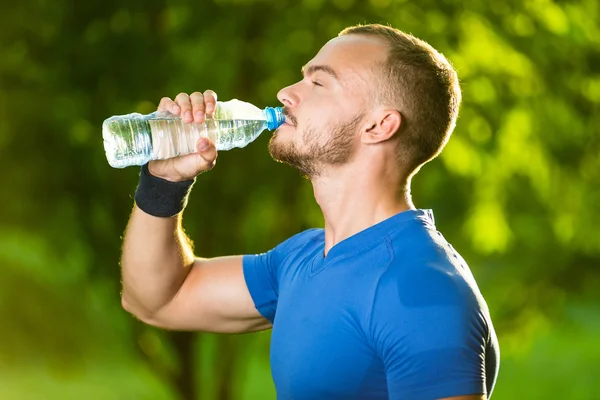 Homme mûr sportif buvant de l'eau d'une bouteille — Photo