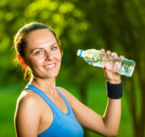 Młoda kobieta picie wody po ćwiczeniach fitness — Zdjęcie stockowe