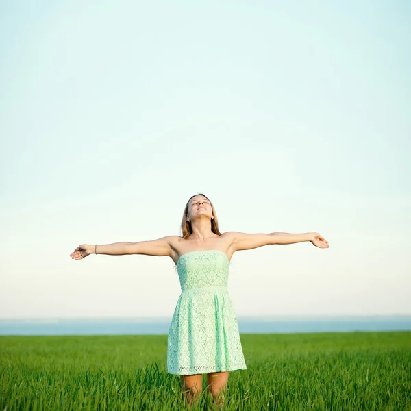 Felicidad mujer estancia al aire libre bajo la luz del sol de la puesta del sol — Foto de Stock