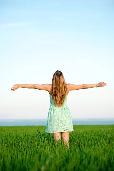 Glückliche Frau bleibt im Sonnenlicht des Sonnenuntergangs draußen — Stockfoto