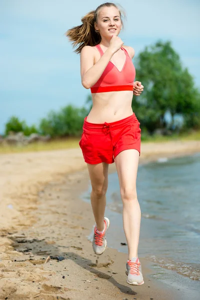 Молода леді біжить на сонячному літньому піщаному пляжі. Тренування. Джог — стокове фото