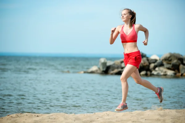 Fiatal hölgy futás a napsütéses nyári homokos strandon. Edzés. Jog — Stock Fotó