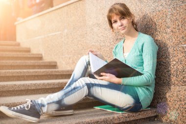 Merdivenlerde oturan ve Not okuma kız